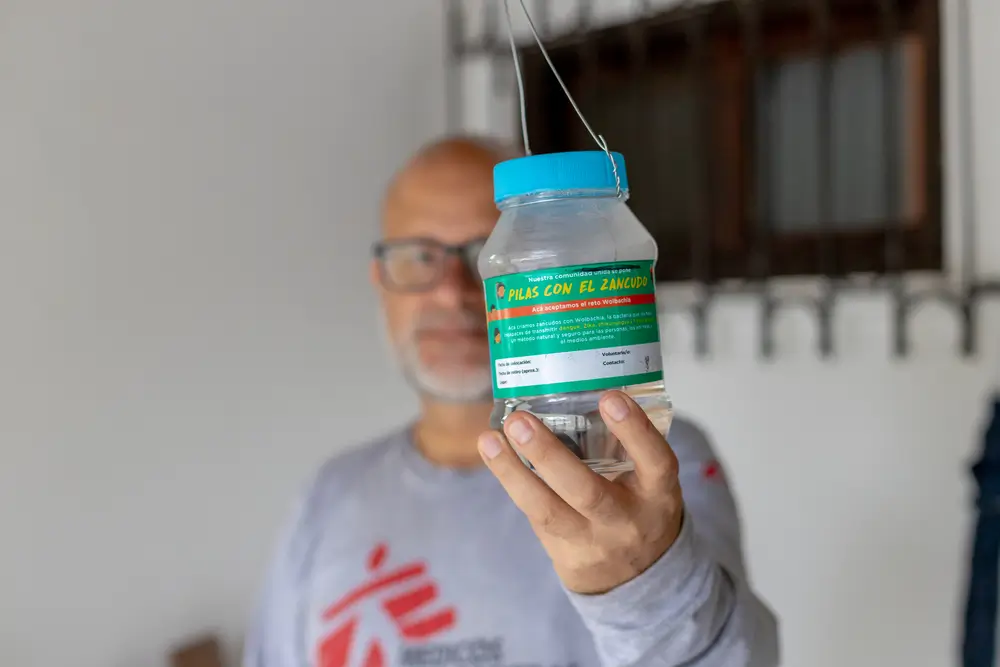 Un integrante de MSF sostiene un frasco con mosquitos con la bacteria Wolbachia, con la que MSF trabajamos desde 2023 para combatir el dengue en Honduras. 