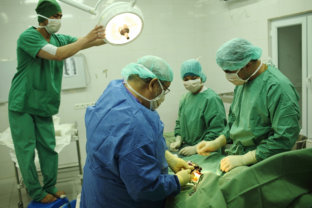 El Dr. Edgar Escalante (en el centro) realiza una cirugía de pierna en el Centro de Traumatología de Kunduz de Médicos Sin Fronteras (MSF) el 19 de mayo de 2015. © Andrew Quilty/Oculi
