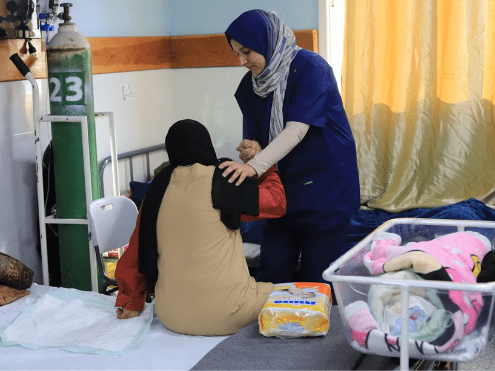 Una enfermera de MSF asiste a una paciente en el hospital de maternidad emiratí de Rafah. Nuestros equipos están apoyando al hospital con atención posnatal para aumentar el período de seguimiento del posparto. Gaza, 15 de enero de 2024. © Mariam Abu Dagga/MSF
