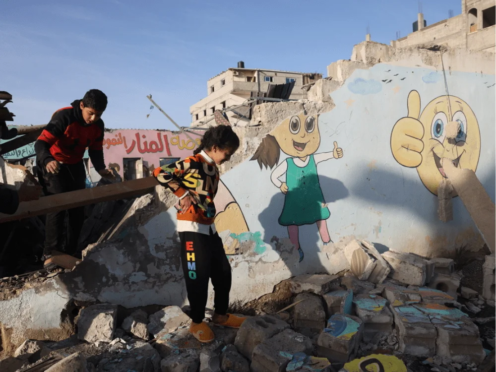 Niños y niñas caminan entre los escombros de un edificio destruido después de que fuera alcanzado por un ataque aéreo israelí. Gaza, 24 de noviembre de 2023. © Mohammed Abed