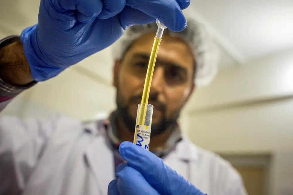 Un técnico de laboratorio prepara cuidadosamente un cartucho para realizar pruebas precisas de hepatitis C con el GeneXpert® en Pakistán