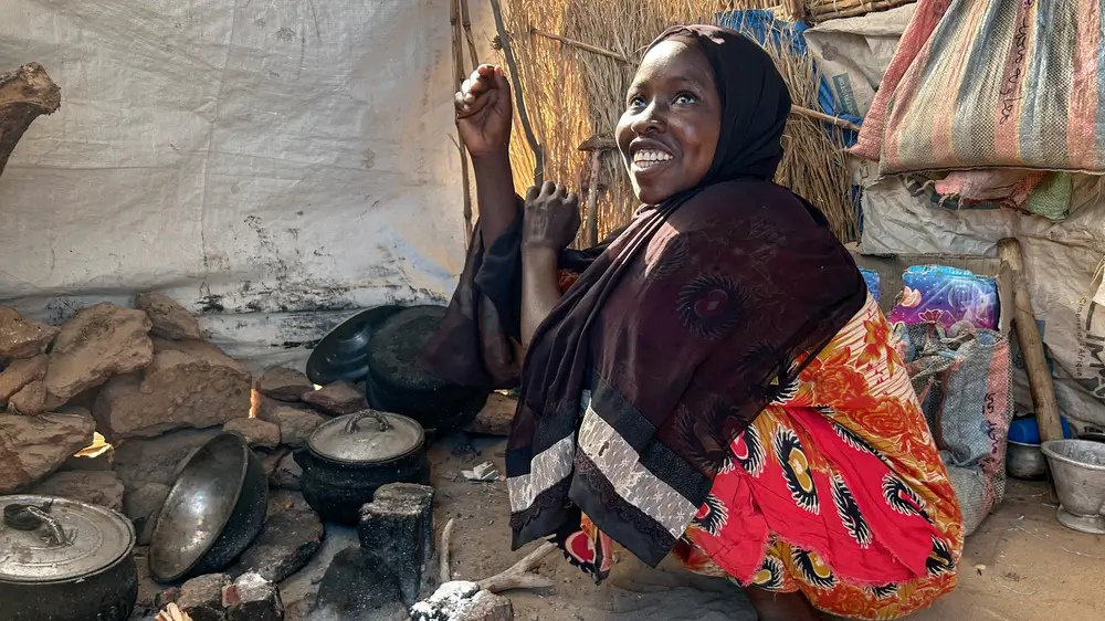 Ghalia muestra el lugar donde cocina para su familia en el campo de refugiados de Abutengue, en el este de Chad.