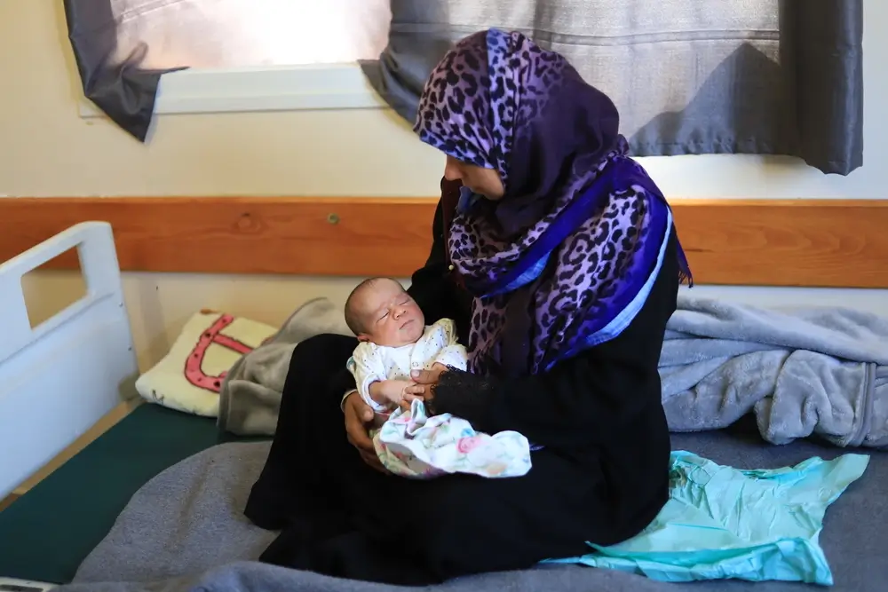 Khadra, y su bebé después de dar a luz en la sala de maternidad el hospital Al-Nasser. 