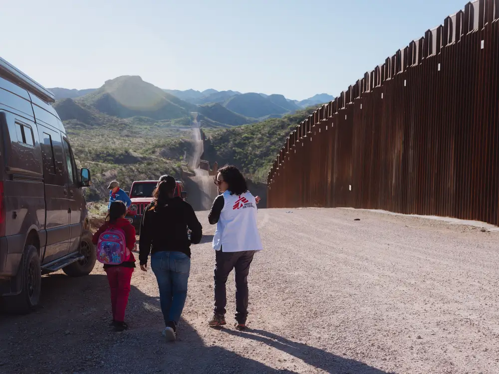 La Dra. Belén Ramirez, coordinadora médica de MSF, habla con una mujer y su hija, mientras sostiene al bebé de la mujer. Recién llegaron de Guatemala