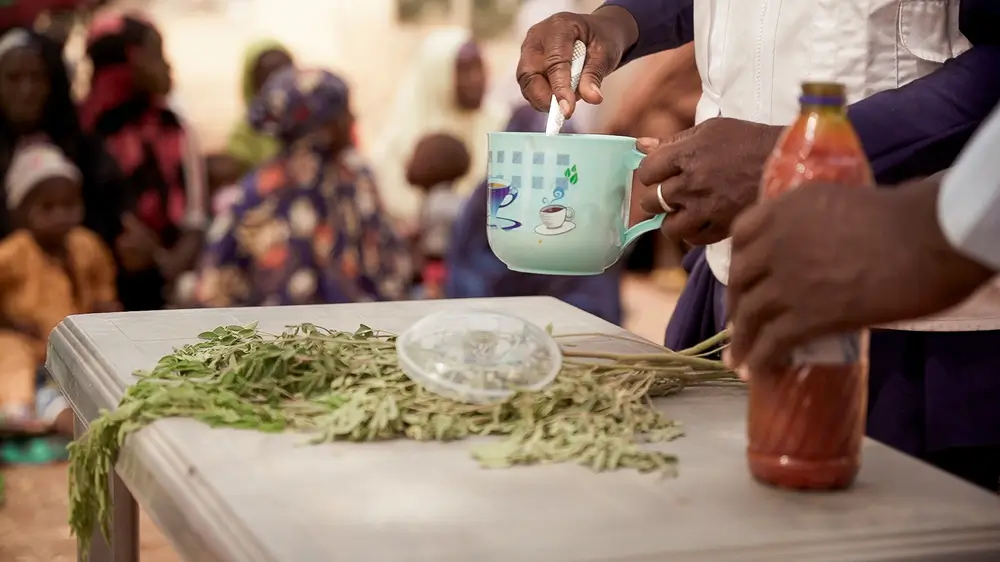 Maryam Muhammad,  sostiene una taza durante una demostración de la receta de Tom Brown en Kebbi, Nigeria.