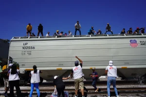 Personal de Médicos Sin Fronteras apoya en la distribución de agua a personas migrantes a bordo de un tren, en su ruta migratoria hacia Estados Unidos