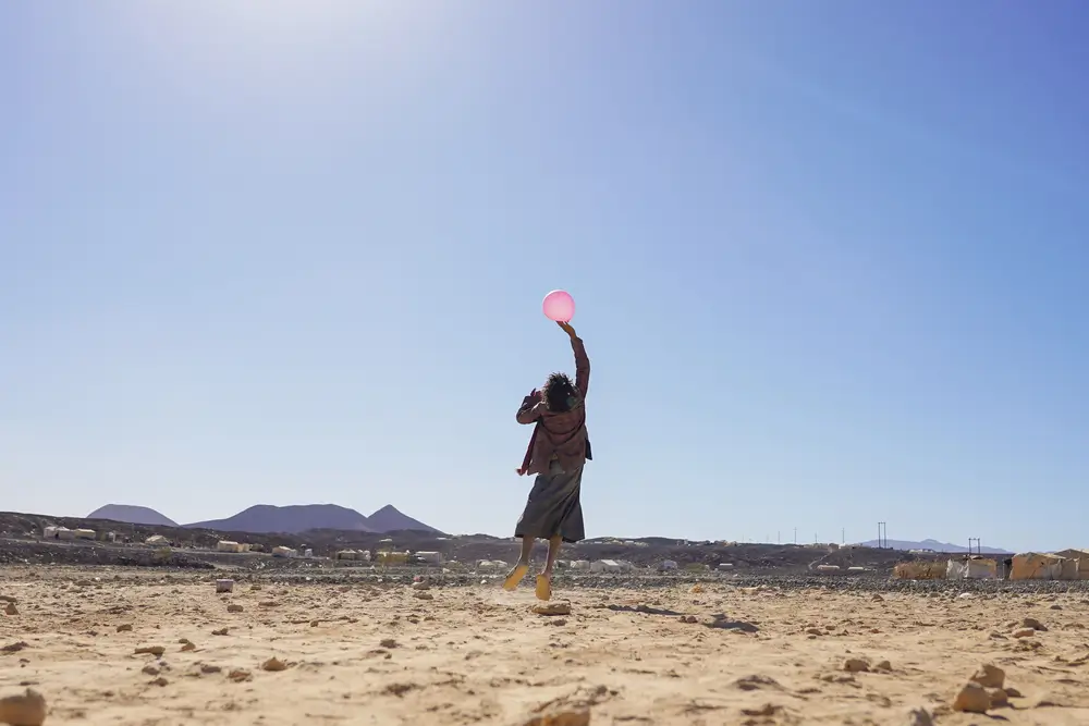 Un niño juega con un globo en el campamento de Al-Sweida, Yemen