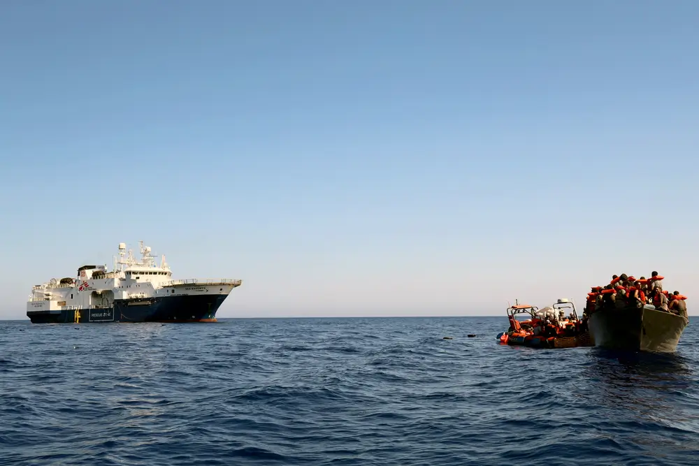 Vista del Geo Barents acercándose aun barco de madera para realizar un rescate de 130 personas.