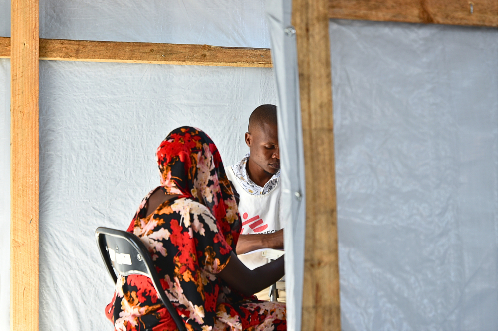 Elvis Badaso, un enfermero, durante la consulta con un paciente en el puesto médico de la escuela secundaria Garsen.