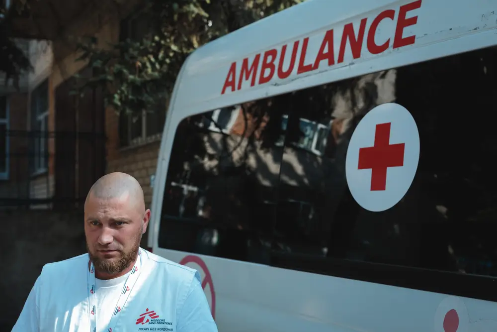 Dmytro Bilous, paramédico de MSF, está de pie junto a la ambulancia.