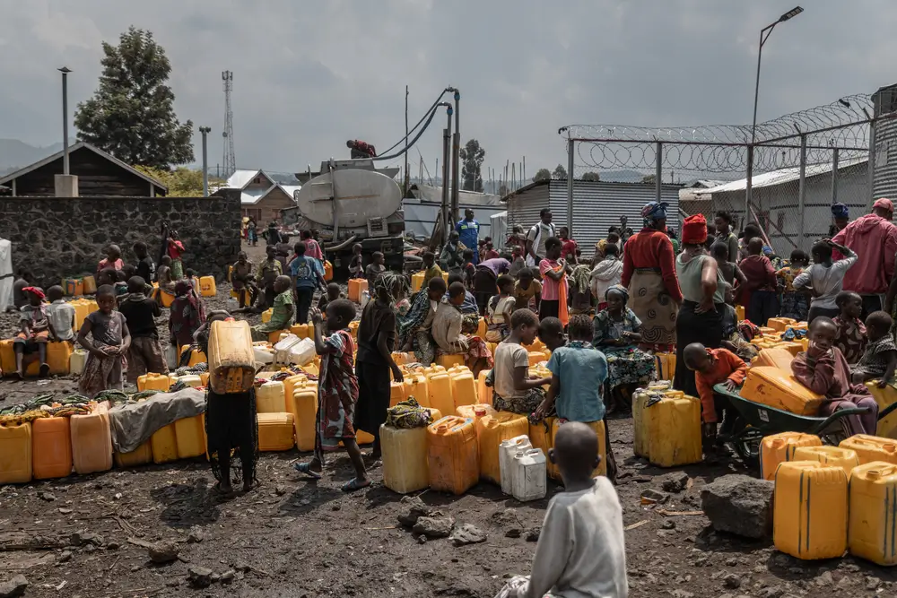 Personas esperando para recibir agua potable en un puntode distribución de MSF.