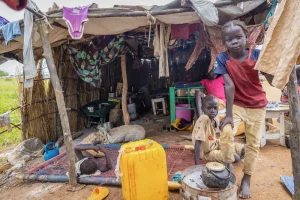 Los hijos de Elizabeth frente a su refugio en la carretera en Abyei, tras la inundación que sumergió su anterior hogar el 22 de agosto.