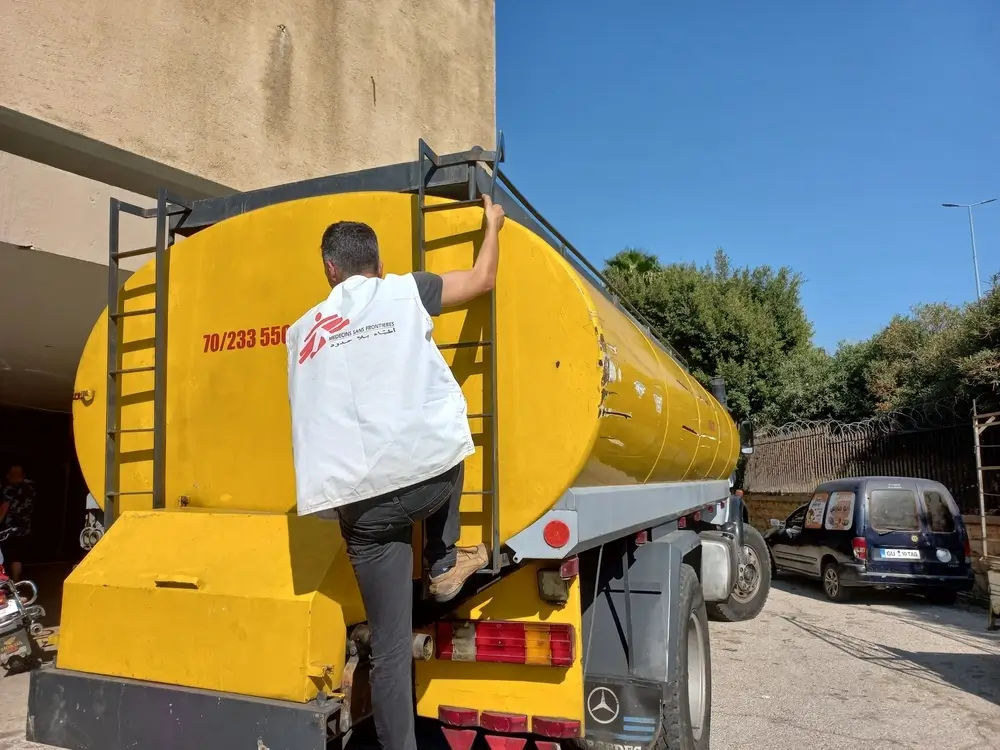 Personal de Médicos Sin Fronteras en un camión cisterna pra distribuir agua a la población desplazada.