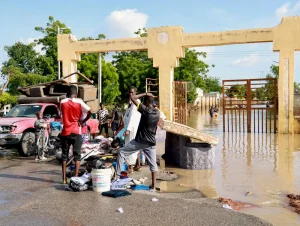 Población de Maiduguri, afectadas por las inundaciones en Nigria trasladan sus pertenencias lejos de sus hogares inundados.