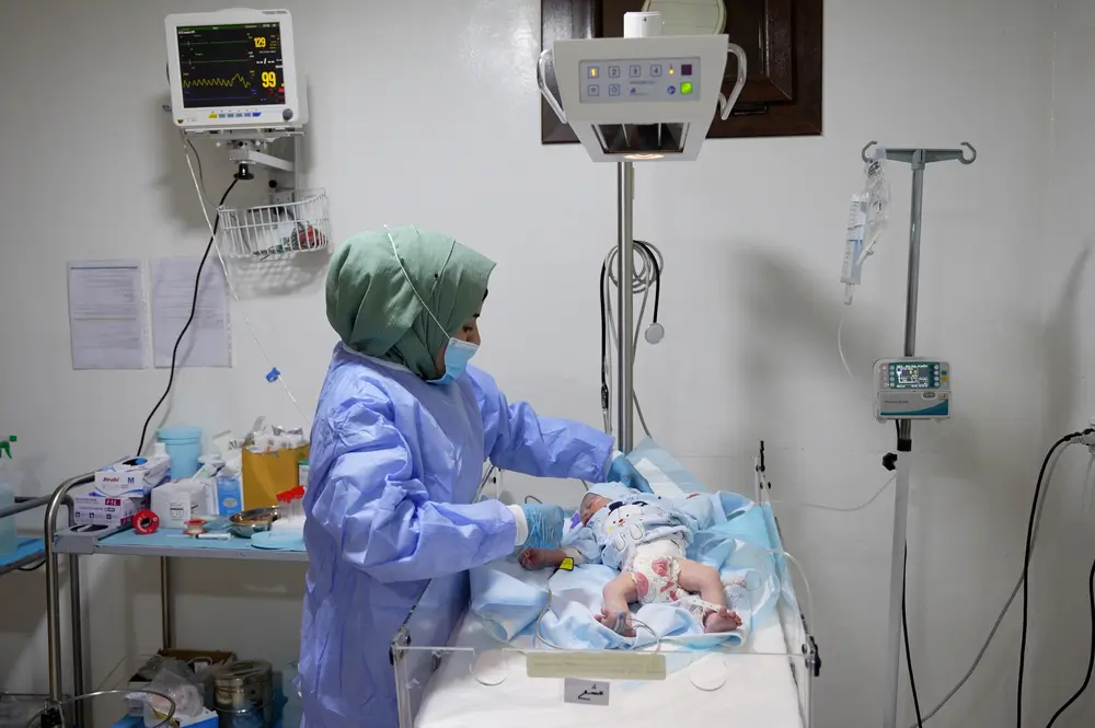 Una enfermera de MSF en el hospital de maternidad de Marée revisa a un recién nacido en la unidad neonatal del hospital.