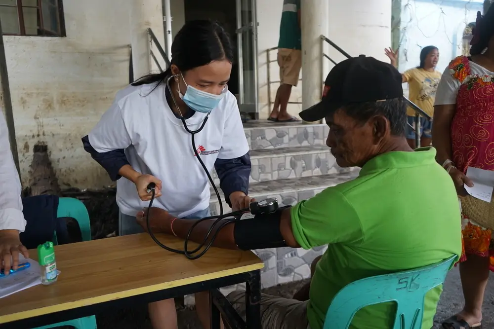 Enfermera de MSF revisa la presión arterial depaciente afectado por las inundaciones tras el paso de la tormenta tropical Trami en Filipinas.