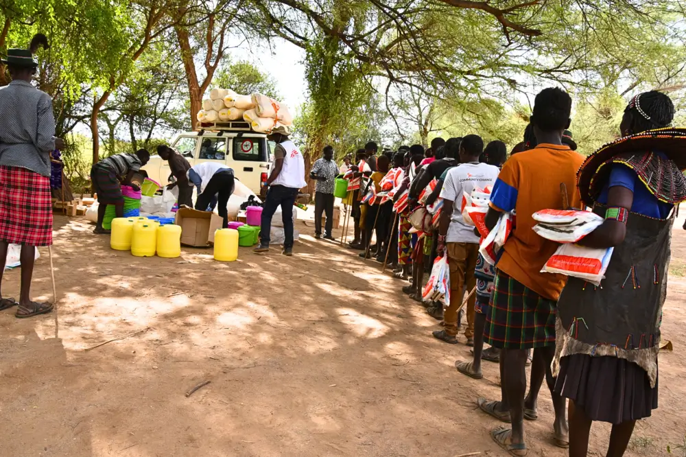 Como medida deprevención de la malaria, as personas se forman durante la distribución de mosquiteros en la aldea de Nasorot en Baringo, Kenia.