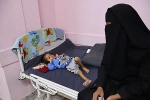 Una madre sentada con su hijo desnutrido en el hospital Nasser, que cuenta con el apoyo de MSF.