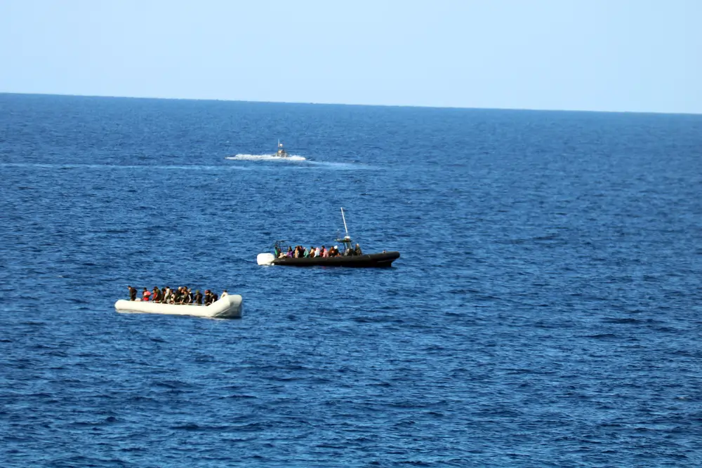 La lancha de goma y, detrás, la lancha rápida de los hombres armados llevándose a mujeres y niños en aguas internacionales.