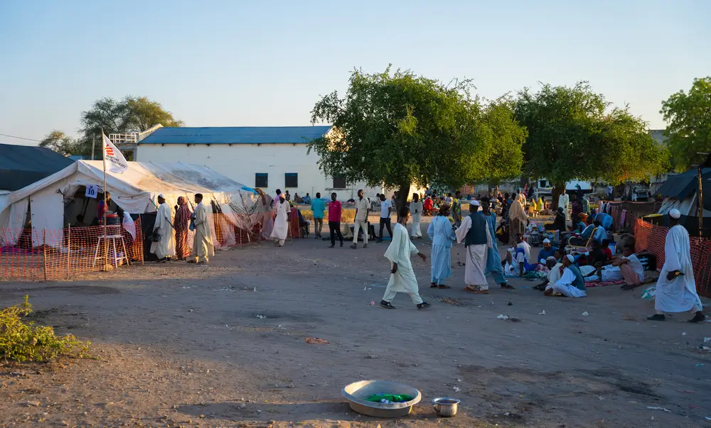 Fuera de la unidad de cuidados pre y posoperatorios del hospital del condado de Renk, los cuidadores esperan para visitar a sus seres queridos. Sudán del Sur, 19 de diciembre de 2024.
