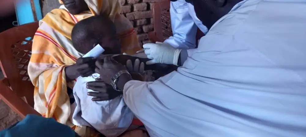 Personal de MSF administra una vacuna contra el sarampión a un niño en Rokero, Sudán.