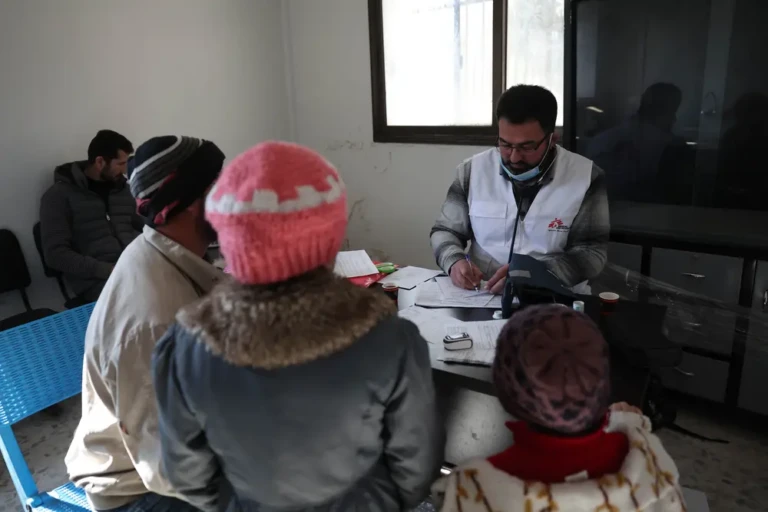 Mohammed Gobasi, trabajador médico de MSF, proporciona una receta a un padre con sus dos hijos en las clínicas móviles de MSF en Guta Oriental. © Omar Haj Kadour