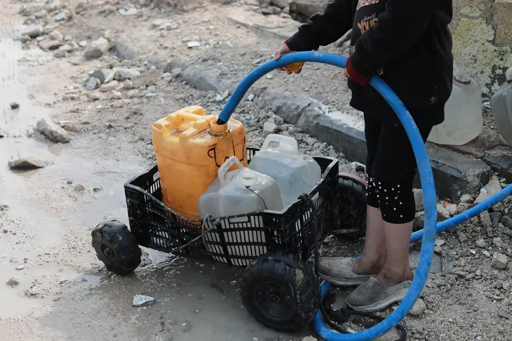 Un niño palestino recoge agua en la ciudad de Beit Lahia, al norte de la Franja de Gaza. Palestina 2025.