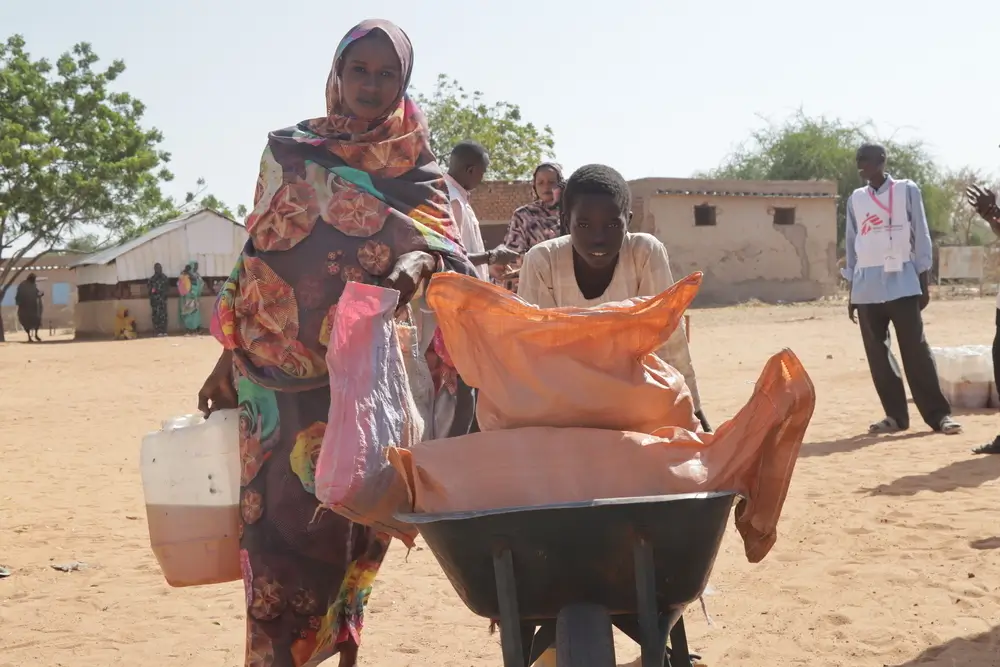 Una madre y su hijo reciben una canasta de alimentos en el campo de personas internamente desplazadas de Autash. Sudán.