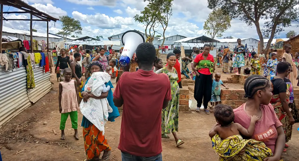 Con un megáfono en la mano, un activista comunitario de MSF recorre el campo de Musenyi para animar a los padres a vacunar a sus hijos contra el sarampión.