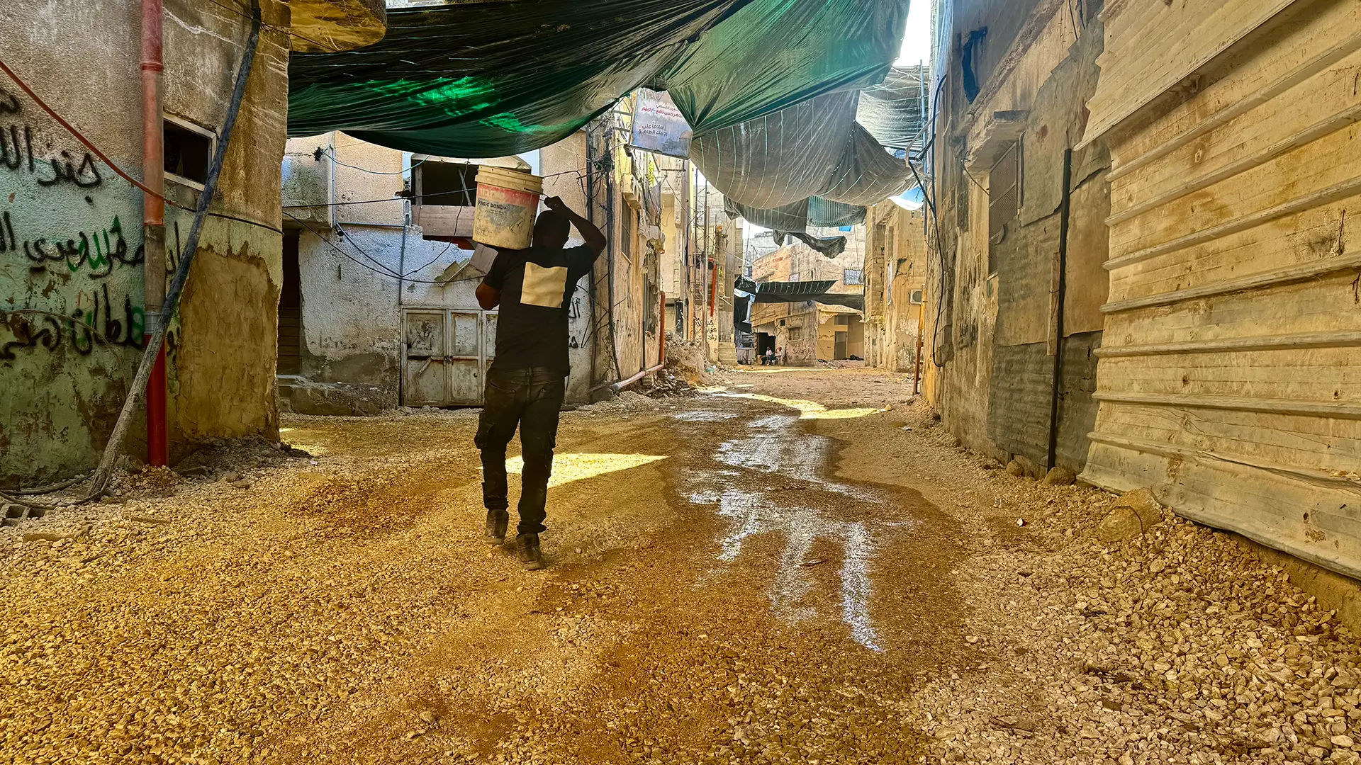 Un residente del campo de refugiados de Tulkarem repara la entrada de su casa, que fue destruida en medio de las continuas incursiones militares israelíes en el campo, que han desplazado a muchos residentes.