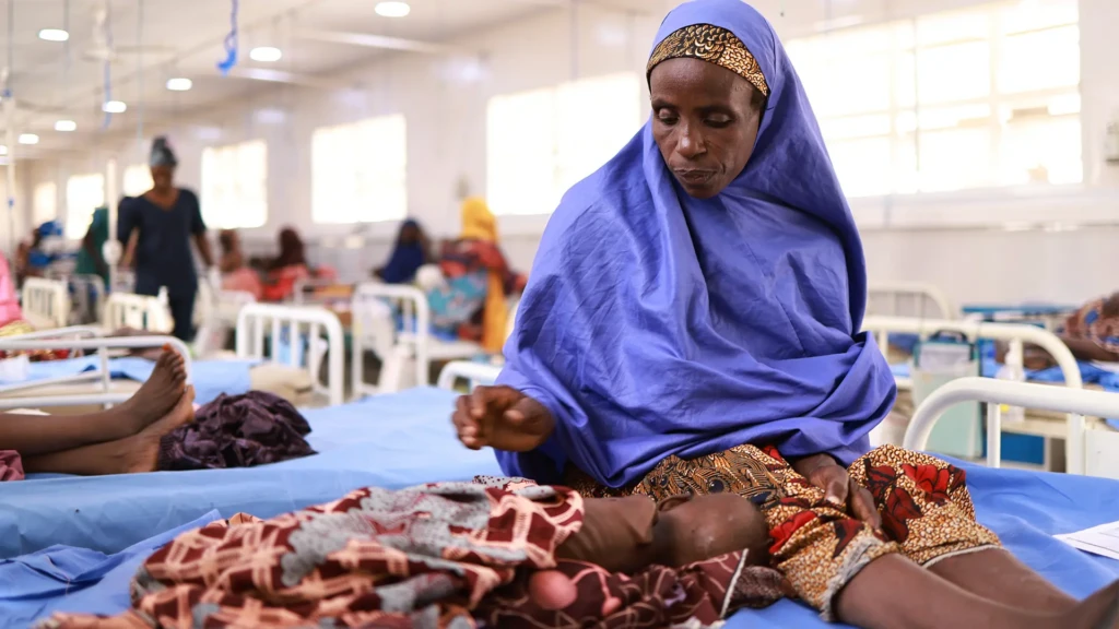 Asma'u se sienta junto a su hija, Shamsiya, quien ha sido ingresada en el centro de alimentación terapéutica para pacientes hospitalizados Kofar Suari por desnutrición, en el estado de Katsina, Nigeria, en octubre de 2024.