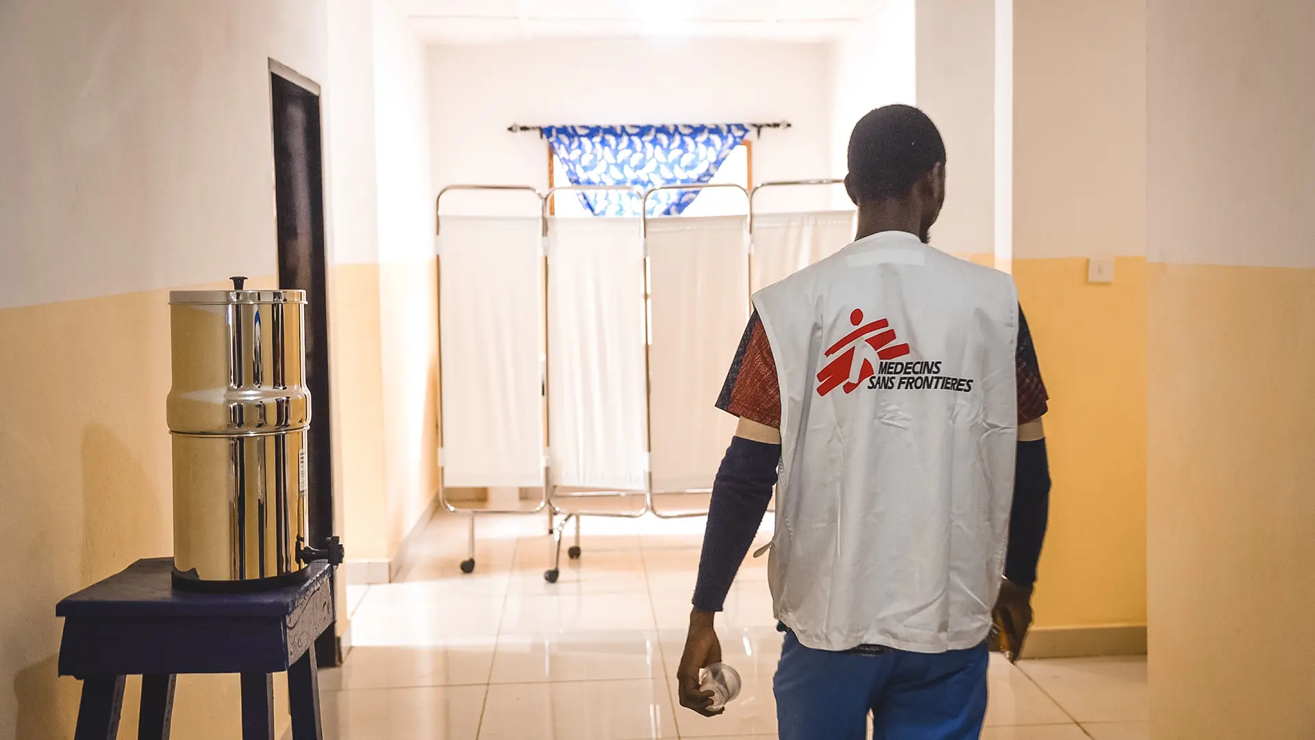 Senessie Mannah, supervisor del equipo de enfermería de MSF, camina por la sala femenina del centro de tratamiento de mpox apoyado por MSF durante la rehabilitación del centro en Freetown, Calaba Town, Sierra Leona.