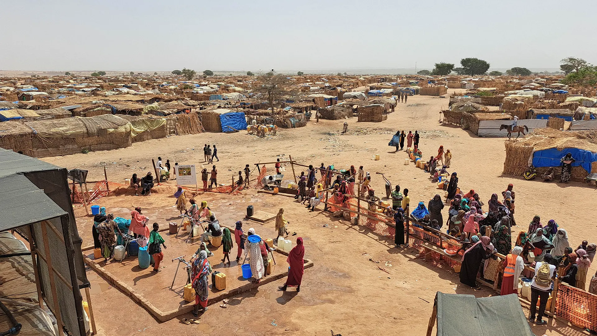 Fila de personas refugiadas esperando a que les distribuyan agua. Chad 2025.