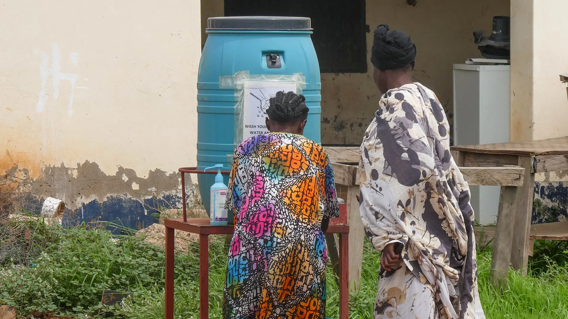 Las personas se lavan las manos antes de ingresar al Hospital Ameth Bek en Abyei como medida de prevención de enfermedades.