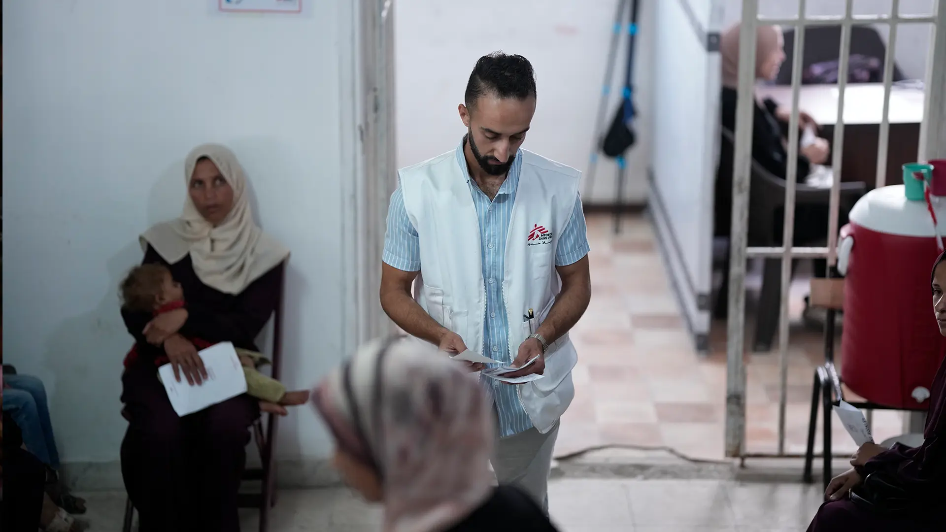 Un miembro del personal de MSF organiza a los pacientes para que vean al personal médico en la clínica de MSF en la ciudad de Gaza, en el norte de Gaza, Palestina, junio de 2025.