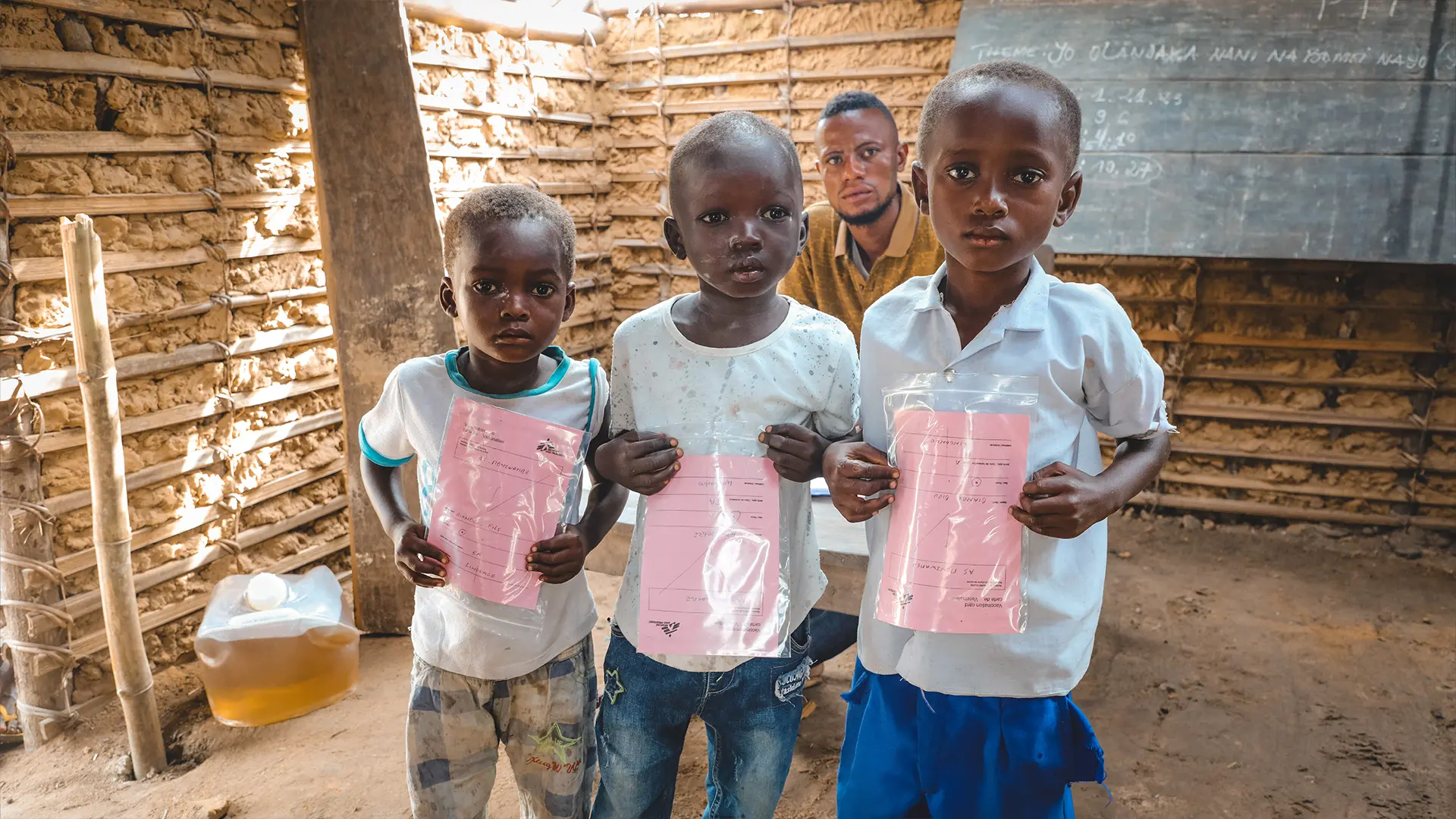Los niños muestran sus tarjetas de vacunación después de la campaña de vacunación de emergencia contra el sarampión apoyada por MSF en el área de salud de Bonzane de la zona de salud de Businga en la provincia de Ubangi Norte.