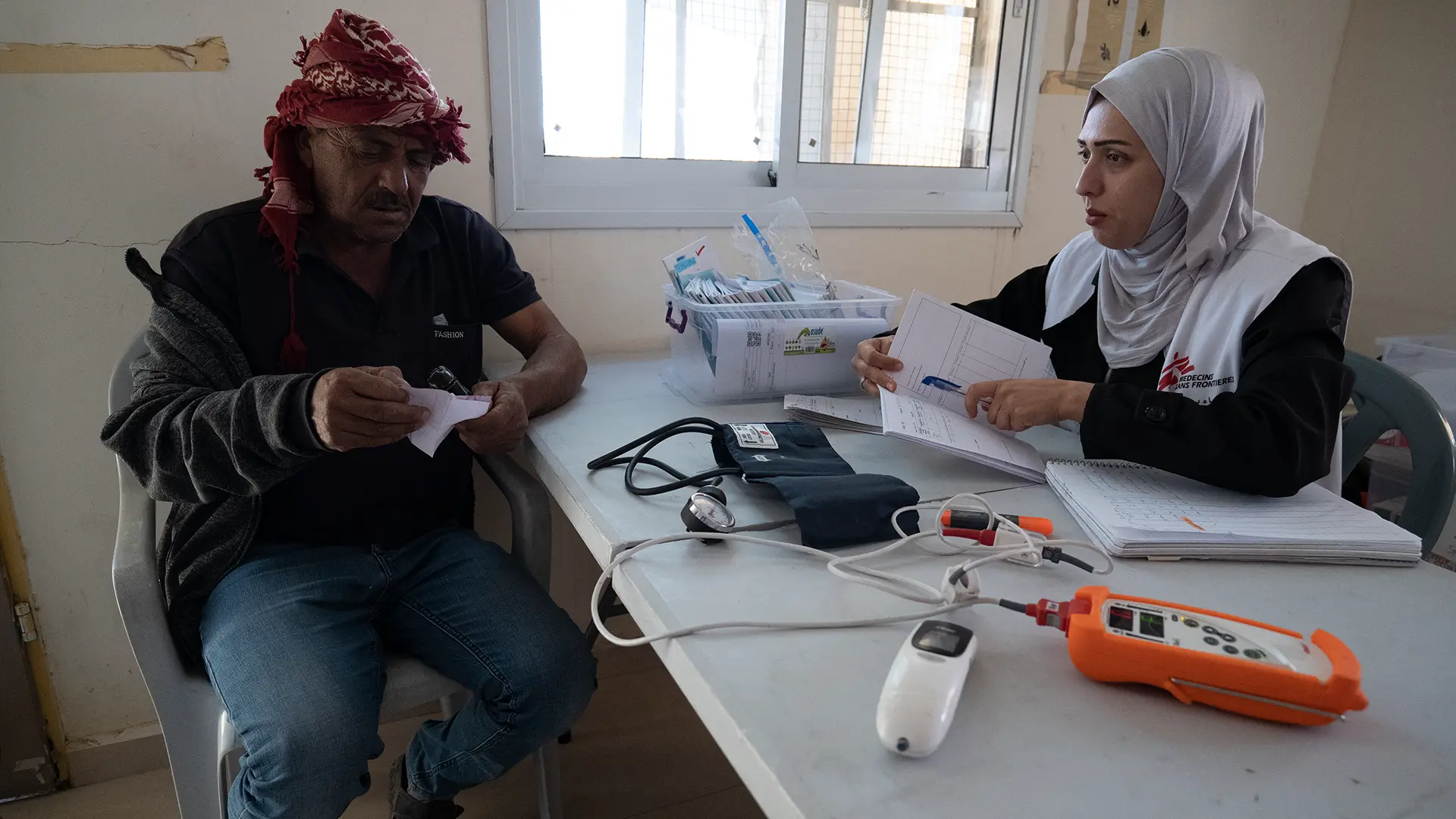 La enfermera de MSF, Manar Abu Amriya, habla con un hombre palestino que recibe atención médica en la clínica móvil Jinba, Masafer Yatta, al sur de Hebrón, Palestina.