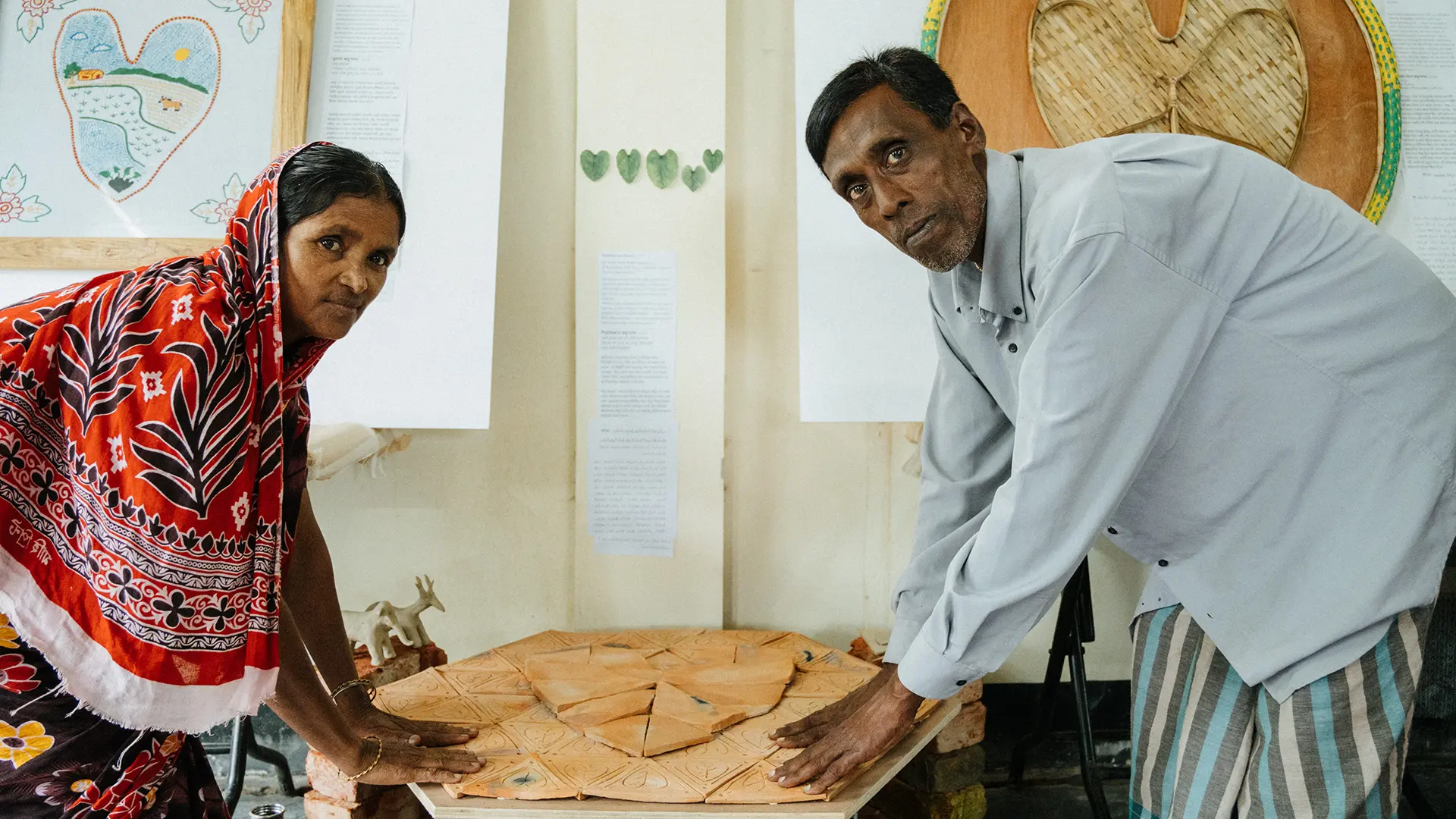El ceramista rohingya Bishi Bala Rudro y Kali Kumar Rudrio junto a su obra. Bangladesh, 2025.