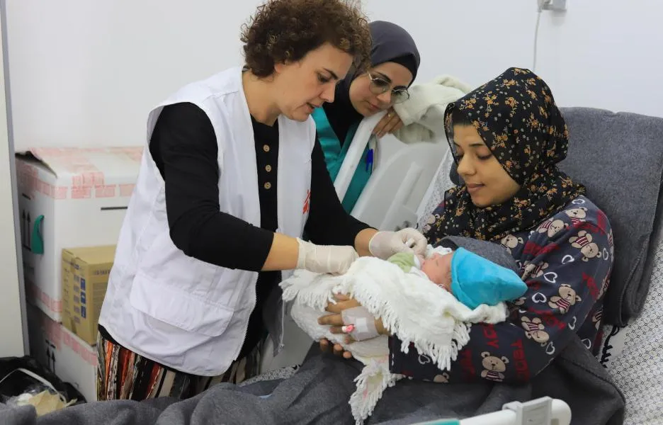 Rita Botelho, comadrona, conversa con una madre mientras examina a su recién nacido. Hospital Emirati, en Rafah, sur de Gaza, 15 de enero de 2024.