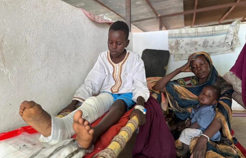 Adil se incorpora en la cama del pabellón pediátrico del hospital de Tawila, mientras su madre, Nawal, y su hermano, Musa, se sientan a su lado.