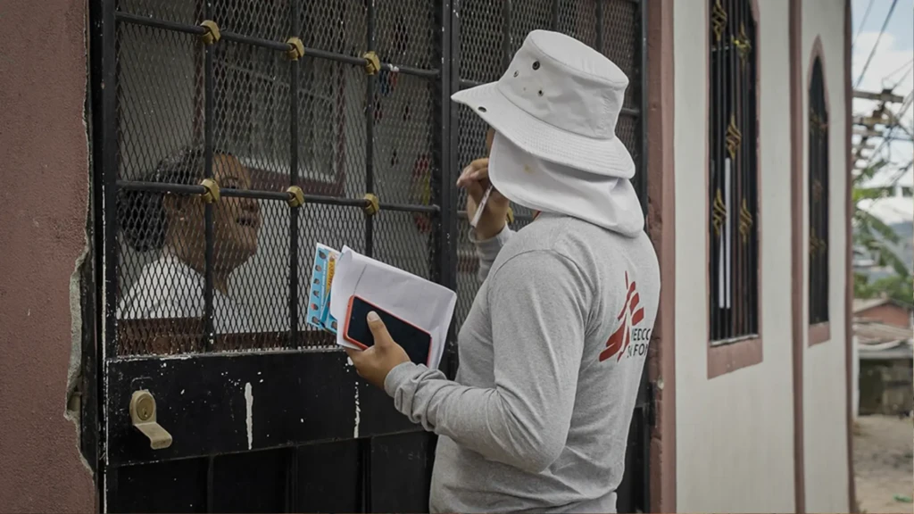 David, promotor de salud de MSF, conversa con una vecina de la comunidad para informarle sobre la liberación de mosquitos con Wolbachia que MSF planea realizar en esta zona de Tegucigalpa.