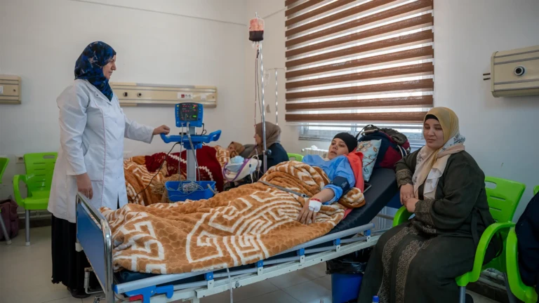 Una enfermera del Hospital Nacional de Nawa atiende a una madre que dio a luz en la sala de maternidad, donde MSF garantiza atención médica integral y seguimiento a las madres y sus hijos.