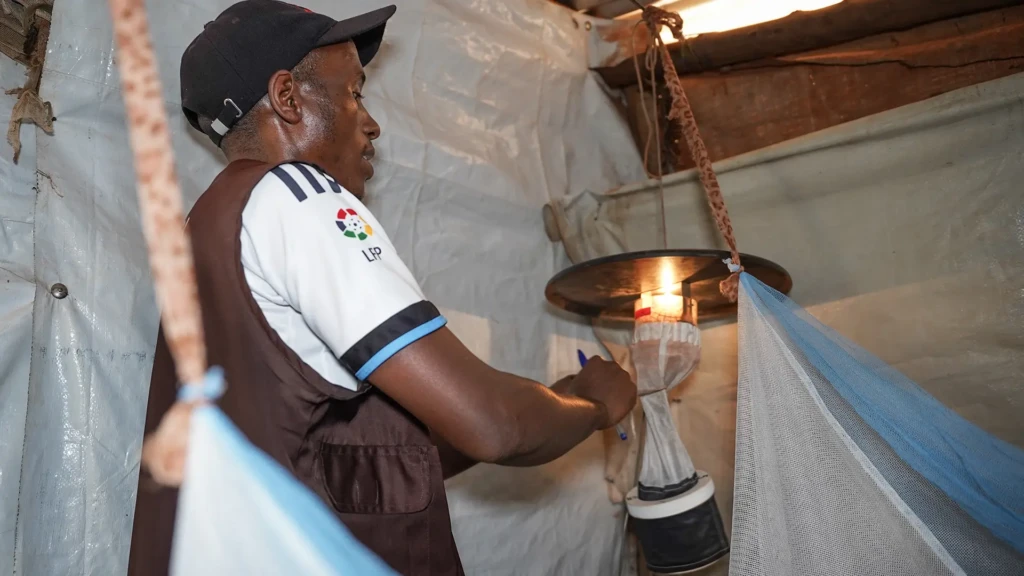 Samuel Nzoyisaba, miembro de la unidad de control de vectores de MSF, instala una trampa para mosquitos dentro de una casa en el campamento de Nduta.