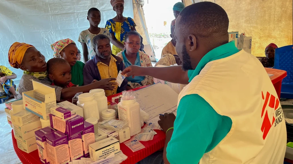 Personas refugiadas congoleñas que viven en el campo de Ndava reciben medicamentos en la clínica móvil de MSF. 