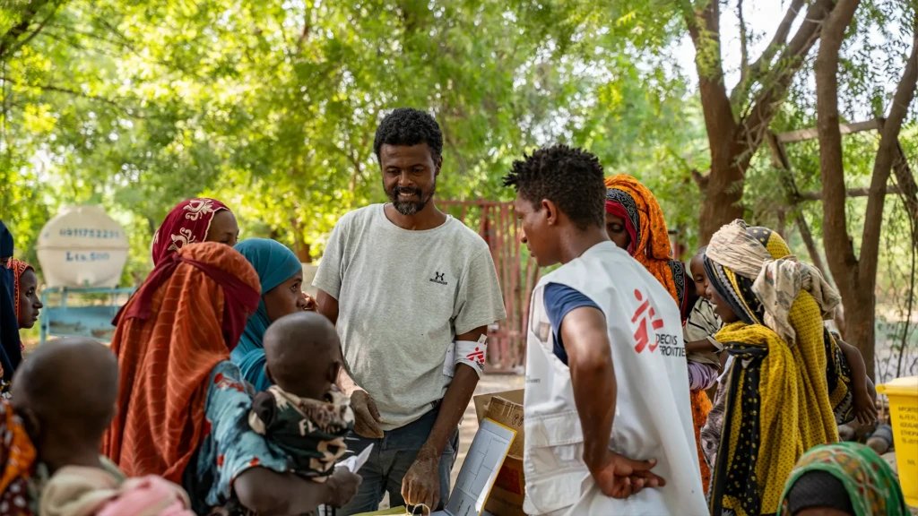 Personal de MSF habla con algunos cuidadores en uno de los puestos de salud donde MSF realiza pruebas MUAC y proporciona plumpy nuts para niños y niñas menores de 5 años.