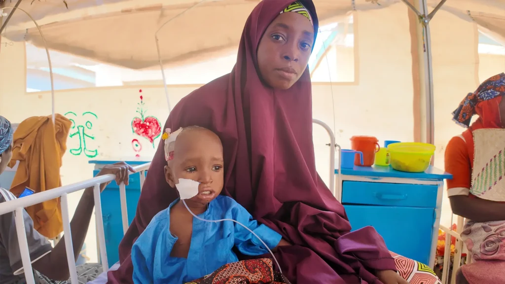Rafaatu Abubakar cuida de su hijo Misbahu durante su recuperación en Gummi. La malaria le provocó una anemia grave, por lo que tuvo que ser ingresado y recibir una transfusión de sangre. El tratamiento gratuito y oportuno ayudó a estabilizar su estado.
