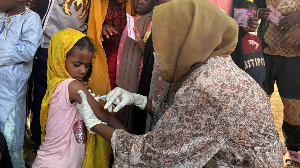Shayma, de ocho años, en el lugar de vacunación de Alsafa, El Geneina. Decidió asistir tras ver a su familia y vecinos unirse a la campaña.