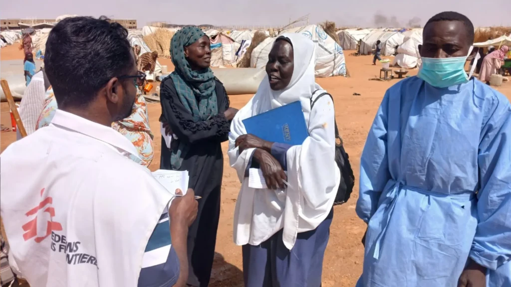 Un trabajador de MSF habla con una mujer en Al Mina Al Muwahad, el mayor campo de personas desplazadas cerca de la ciudad de El Obeid.