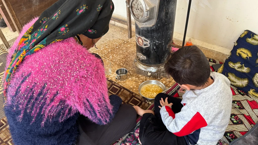 Layla Tobal, mujer de 42 años de Afrin, y su hijo de 5 años comiendo sopa en uno de los centros colectivos de Qamishli.