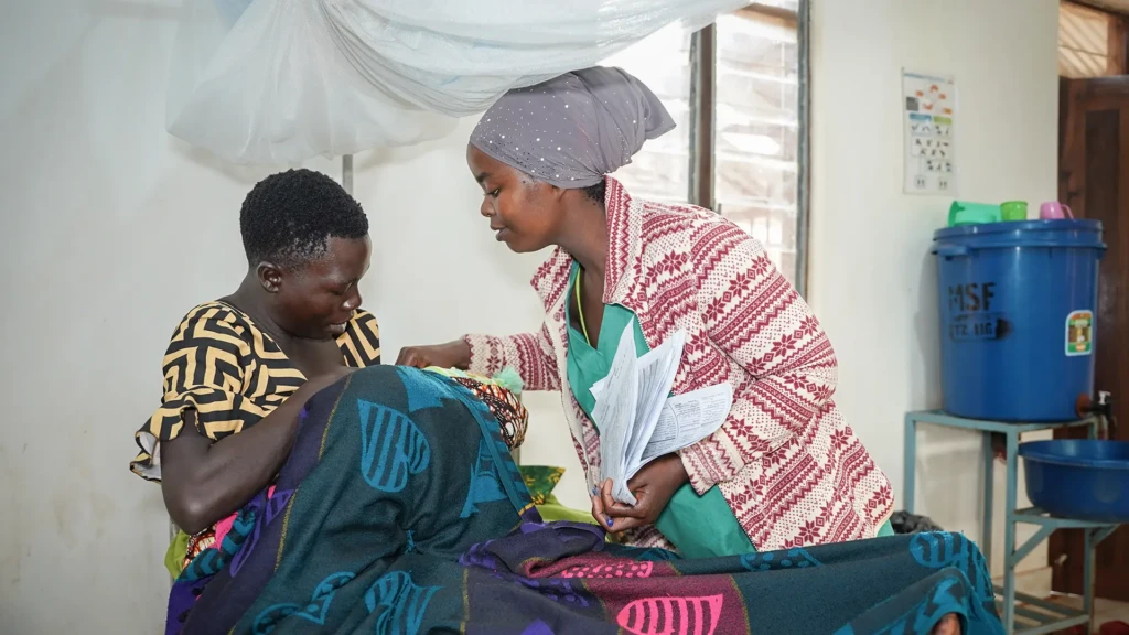 Una auxiliar de enfermería de MSF y una madre atendiendo a un bebé en la sala de maternidad del hospital de MSF en el campamento de Nduta, Tanzania.
